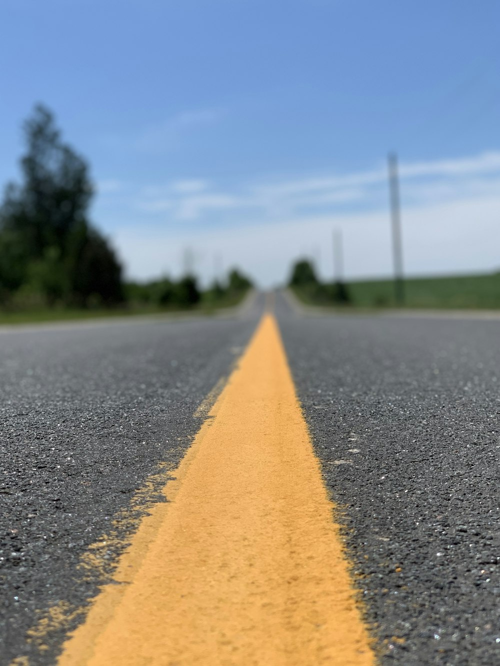 yellow line on gray asphalt road during daytime
