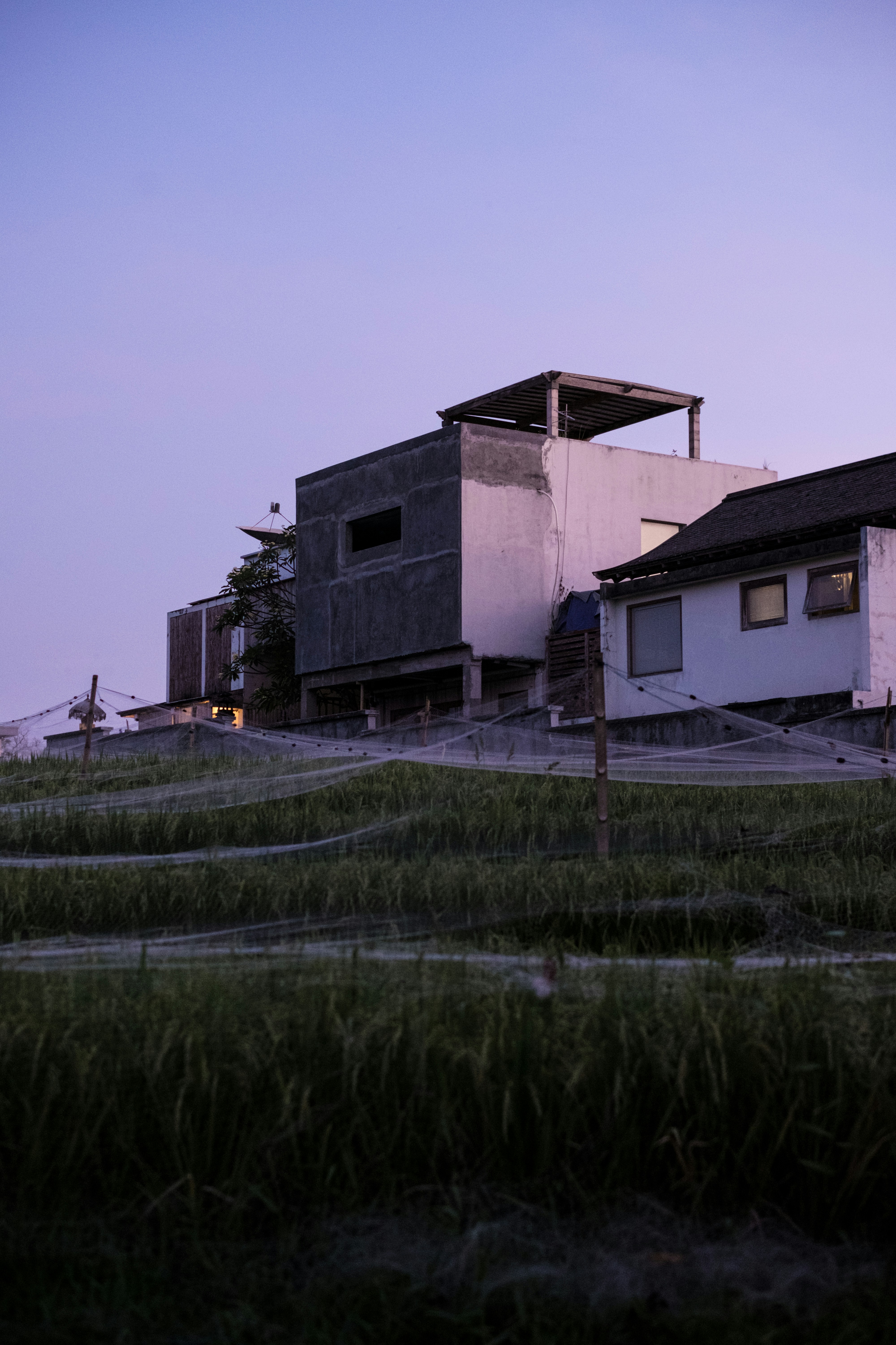 White concrete house beside green grass field during daytime photo