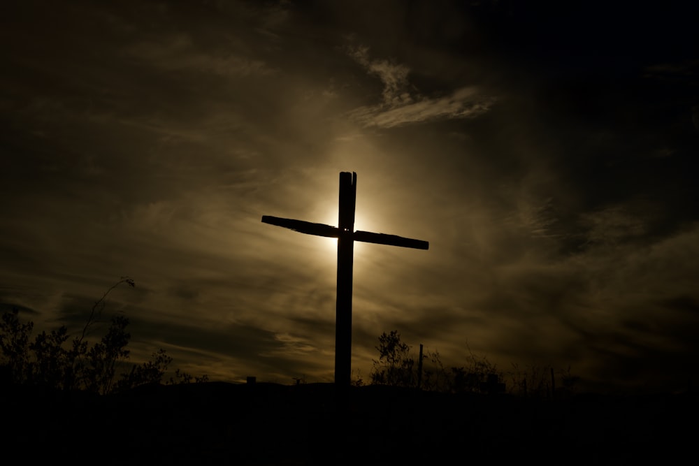 日中の曇り空の下での茶色の木製の十字架