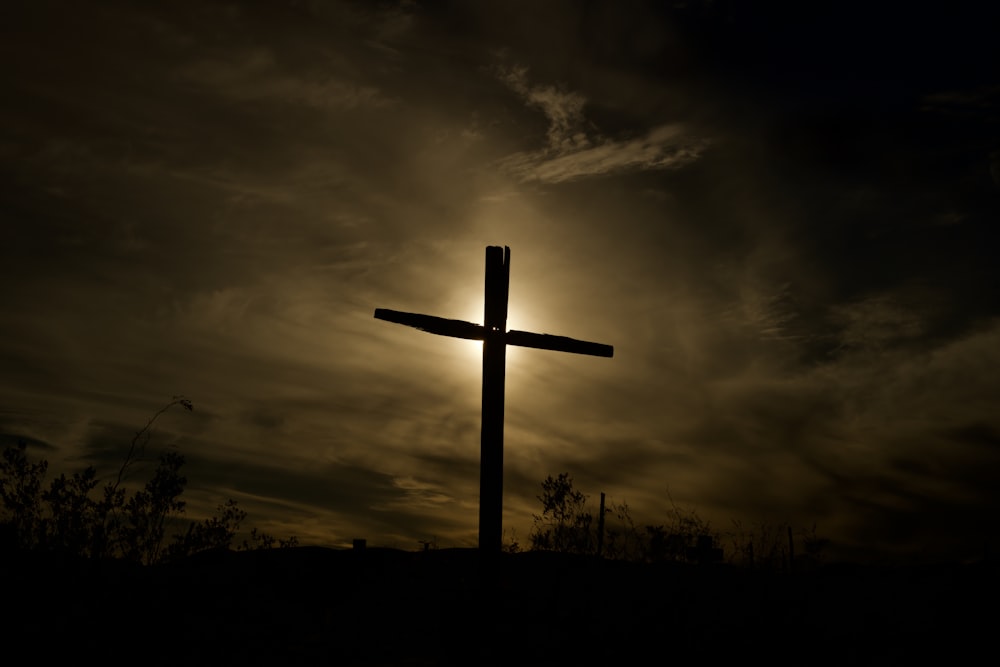 Croix en bois marron sous un ciel nuageux pendant la journée