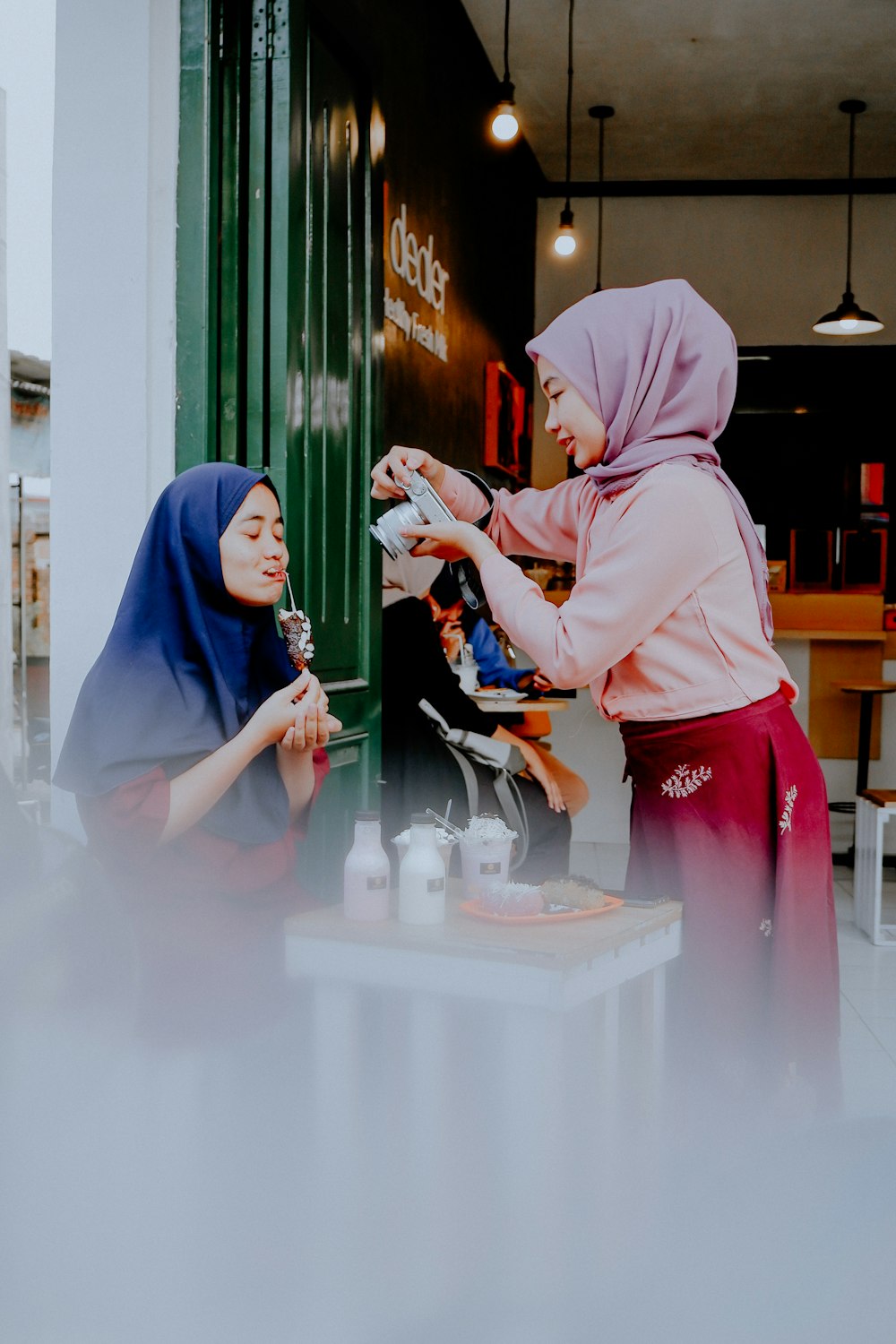 Frau in rosa Hijab und Abaya hält Smartphone