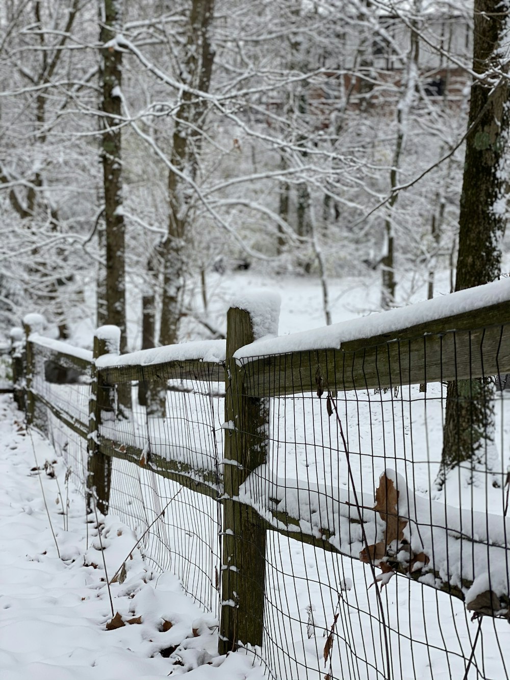 brauner Holzzaun mit Schnee bedeckt