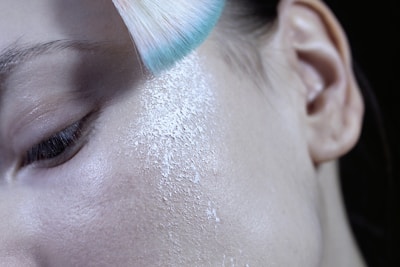 A close-up of a model applying face powder for a flawless finish.