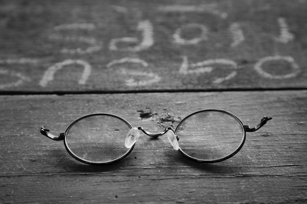 occhiali da vista con montatura argentata su superficie in legno
