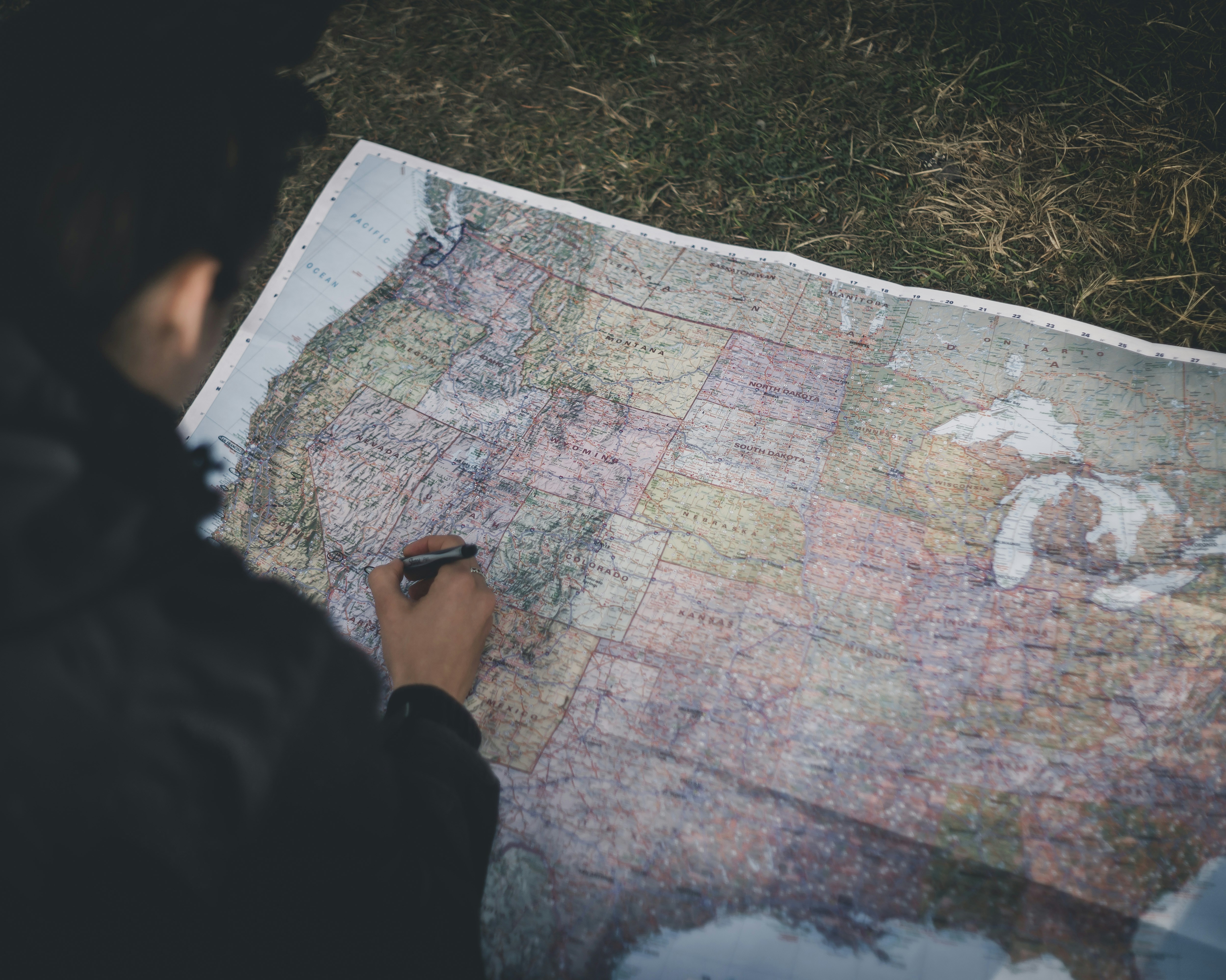 Person in schwarzer Jacke hält Karte