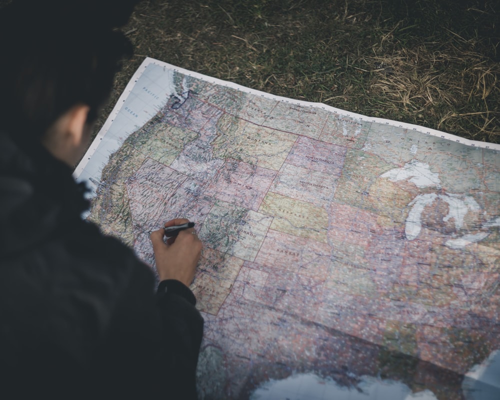 person in black jacket holding map