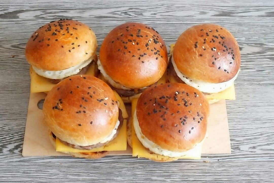 three burger on white ceramic plate, 10. Cover nicely with the second half of the bun.