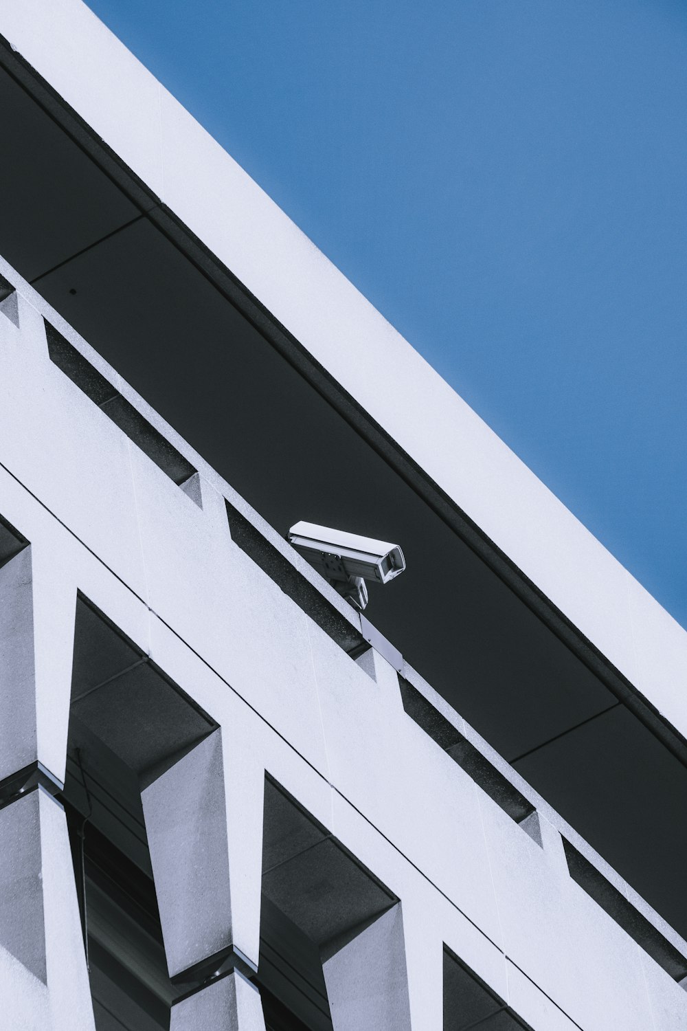 Edificio in cemento bianco e nero sotto il cielo blu durante il giorno