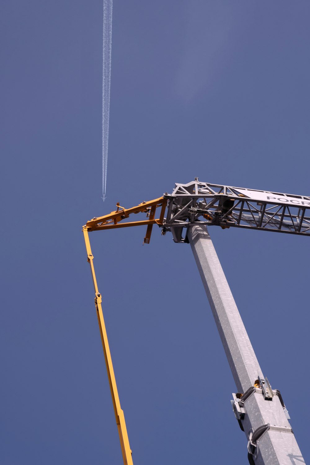 gray and yellow crane under blue sky during daytime