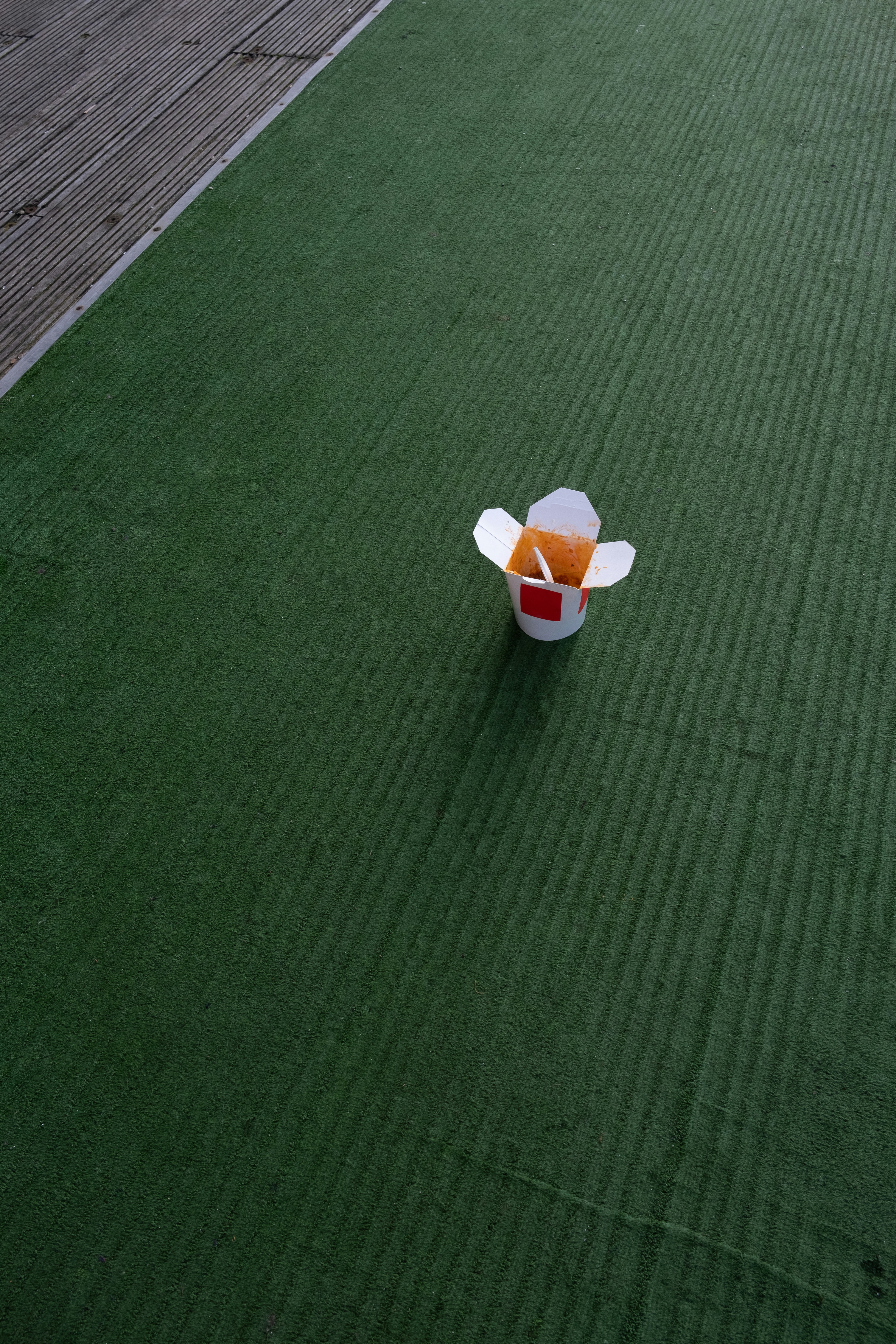 white and orange plastic cup on green textile