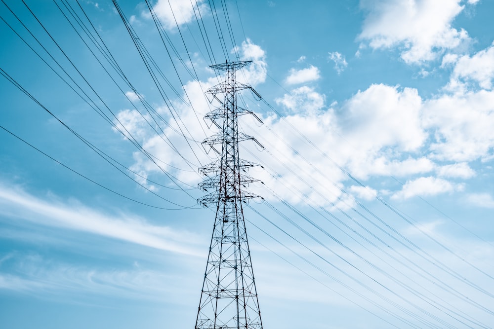 torre eléctrica negra bajo el cielo azul y nubes blancas durante el día