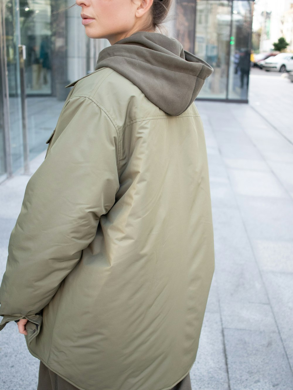 person in brown coat walking on sidewalk during daytime