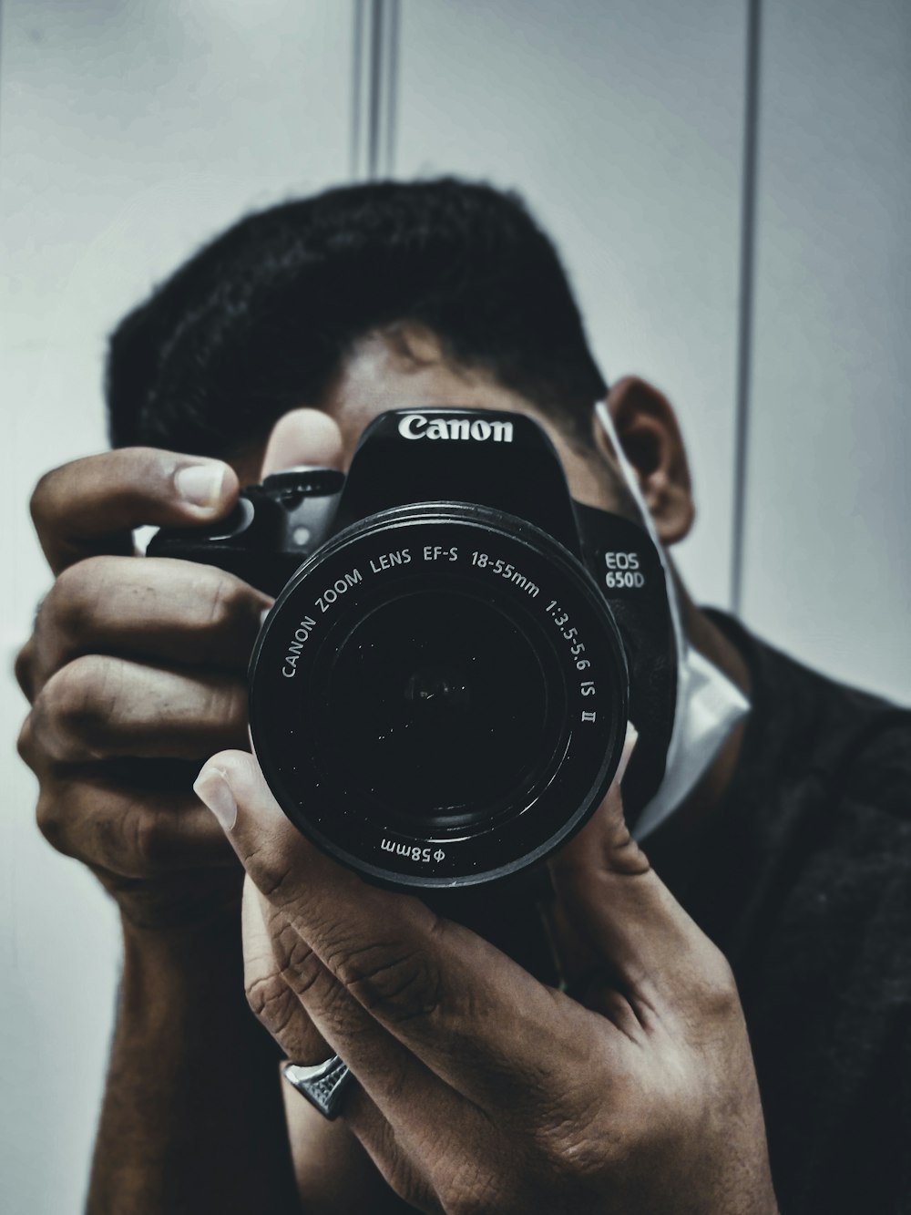 Hombre sosteniendo una cámara DSLR Nikon negra