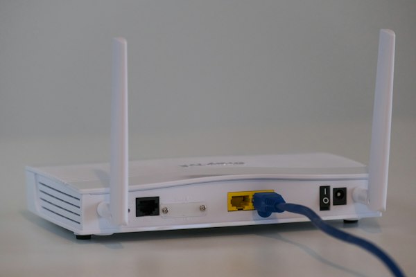 Roteador Wi-Fi branco com cabo de rede conectado