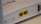 A close-up view of a white rectangular electronic device featuring two yellow Ethernet ports labeled P1 and P2. It has a smooth surface with some text that appears embossed on the top.