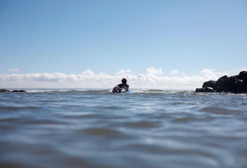 2 person in water under blue sky during daytime