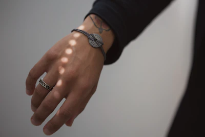 A bright, sunlit corner with a hand wearing a simple, affordable bracelet.