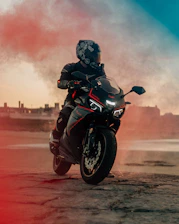 man in black motorcycle helmet riding motorcycle on brown dirt road during daytime