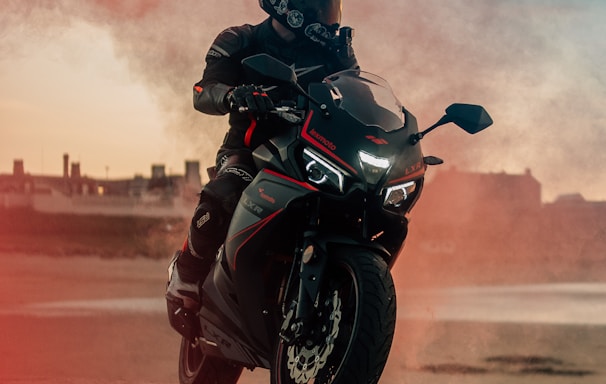 man in black motorcycle helmet riding motorcycle on brown dirt road during daytime