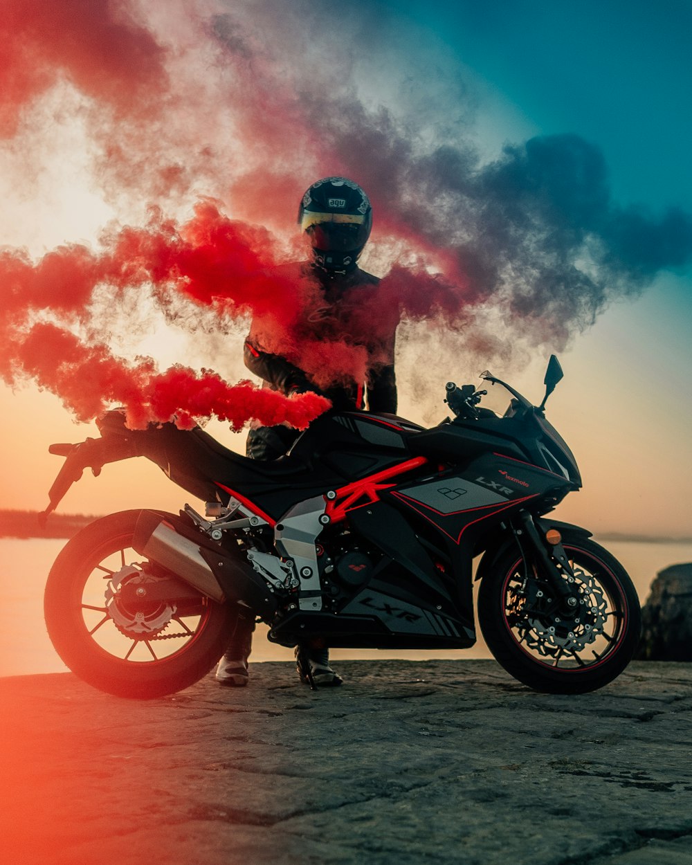 man in black and red jacket riding orange and black sports bike