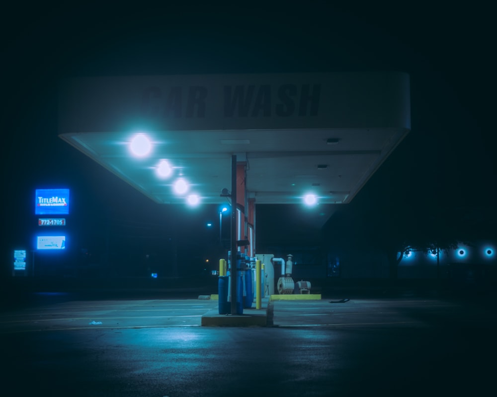 a gas station at night with lights on