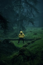person in yellow hoodie standing on green grass field during daytime