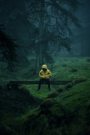 person in yellow hoodie standing on green grass field during daytime