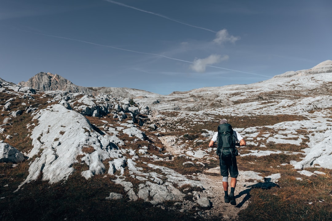 man in black jacket standing on rocky hill during daytime