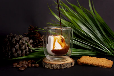 A steaming cup of rich mushroom coffee beside a small jar of homemade fruit butter.