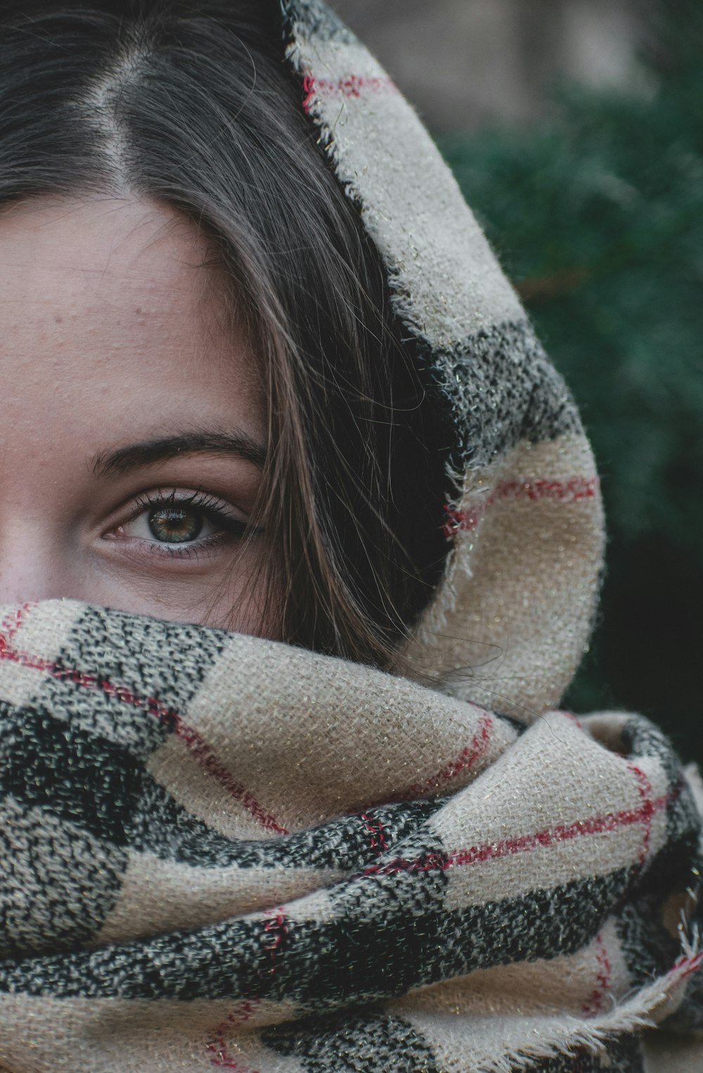 woman covering her face with white and red scarf