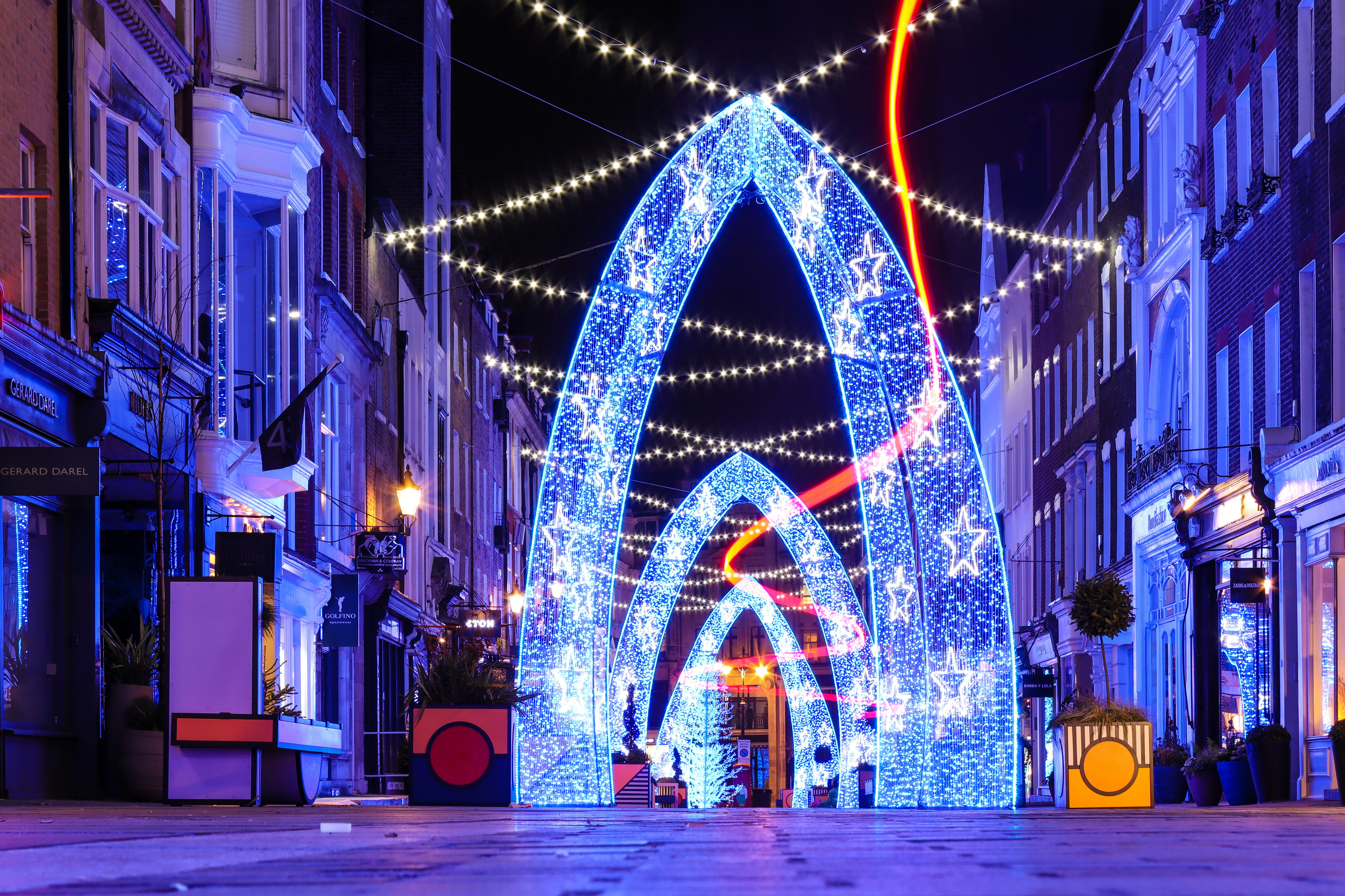 Blue and yellow string lights on street during night time photo Free London Image on Unsplash