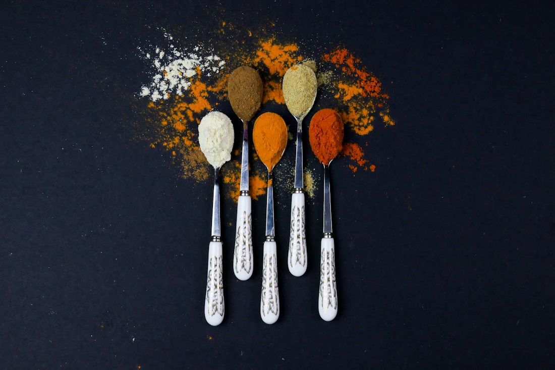 Ground spices arranged in clean metal scoops for packaging selection