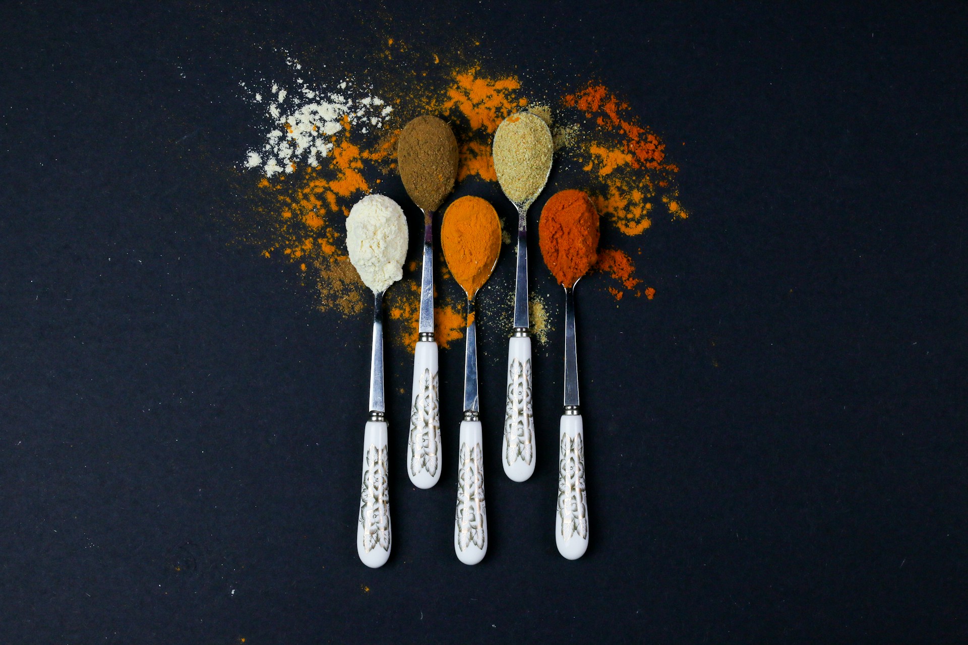 white and silver spoons on black surface