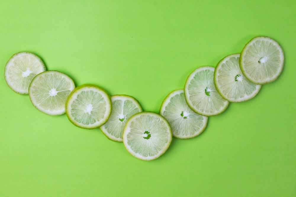 limão fatiado na superfície verde