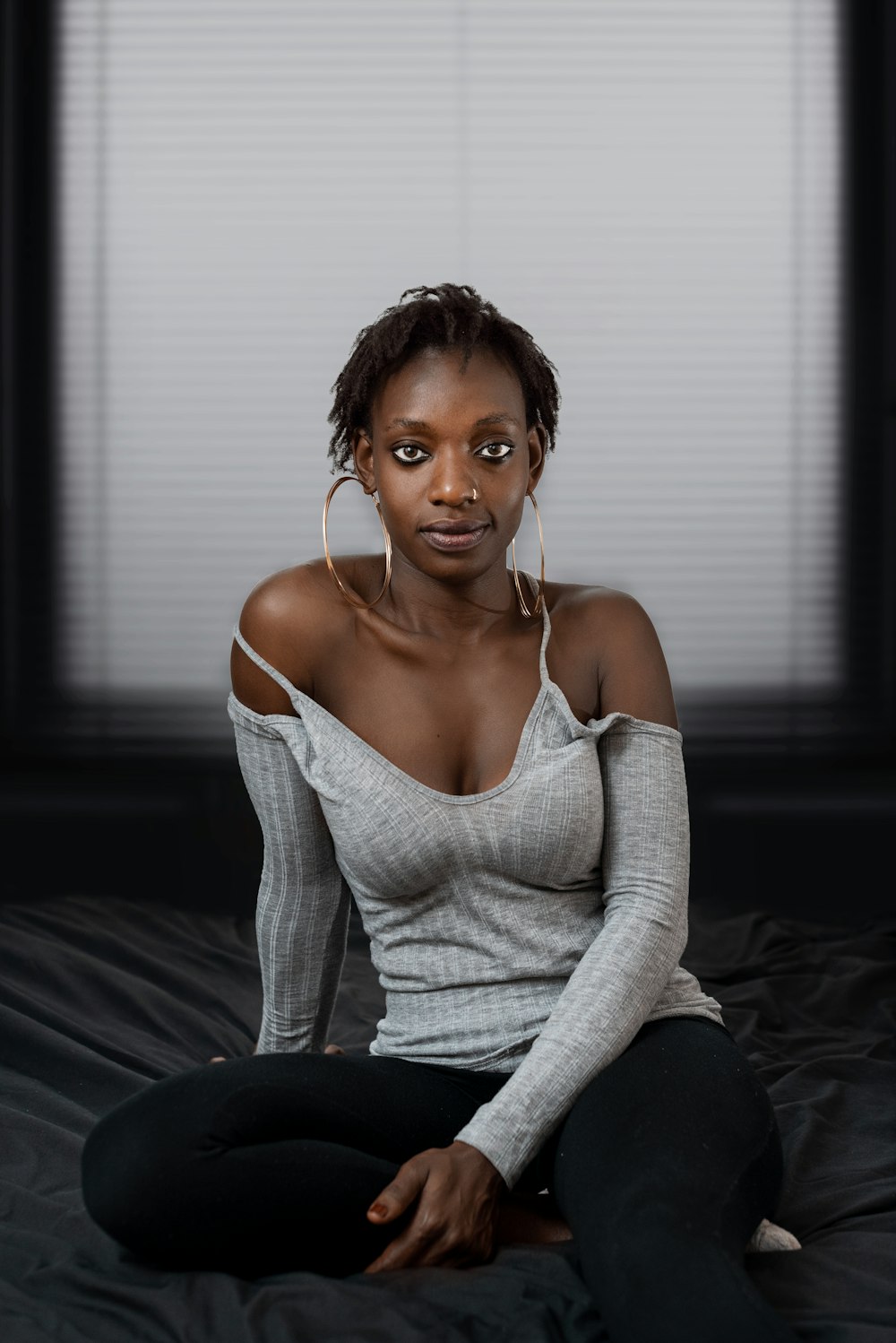 woman in white knit sweater and black pants sitting on black couch
