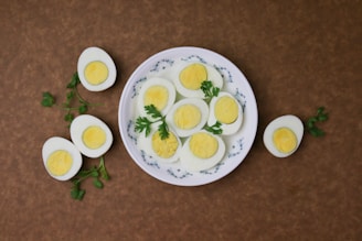 Boiled eggs sliced neatly on a plate with a sprinkle of spices.