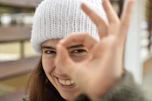 smiling woman wearing white knit cap