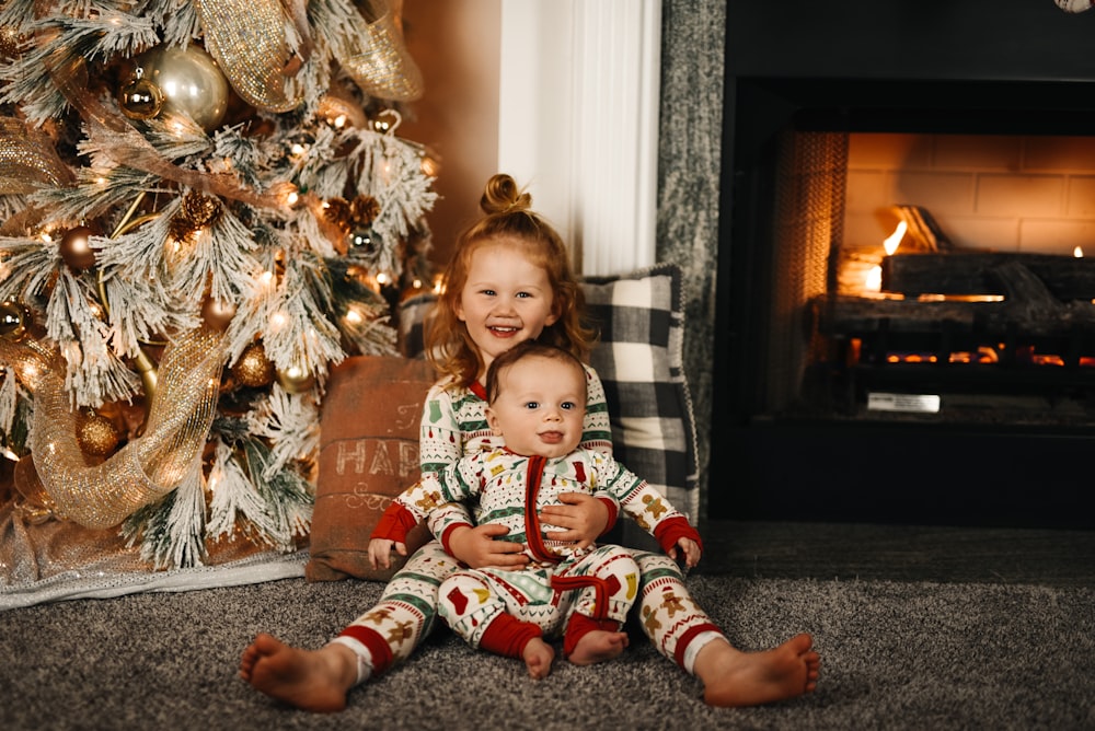 girl in red and white plaid pants sitting on floor beside brown and white floral sofa