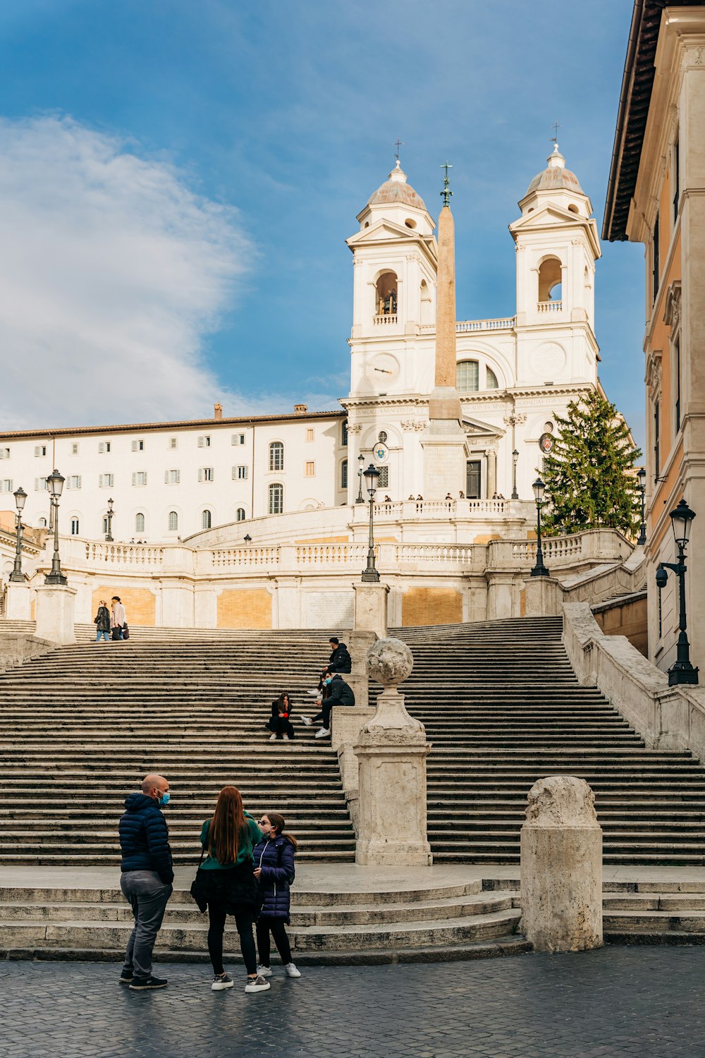 people walking on stairs near white concrete building during daytime