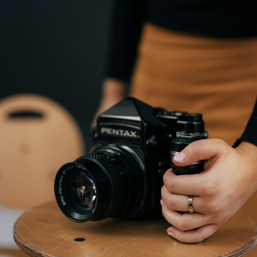 person holding black nikon dslr camera