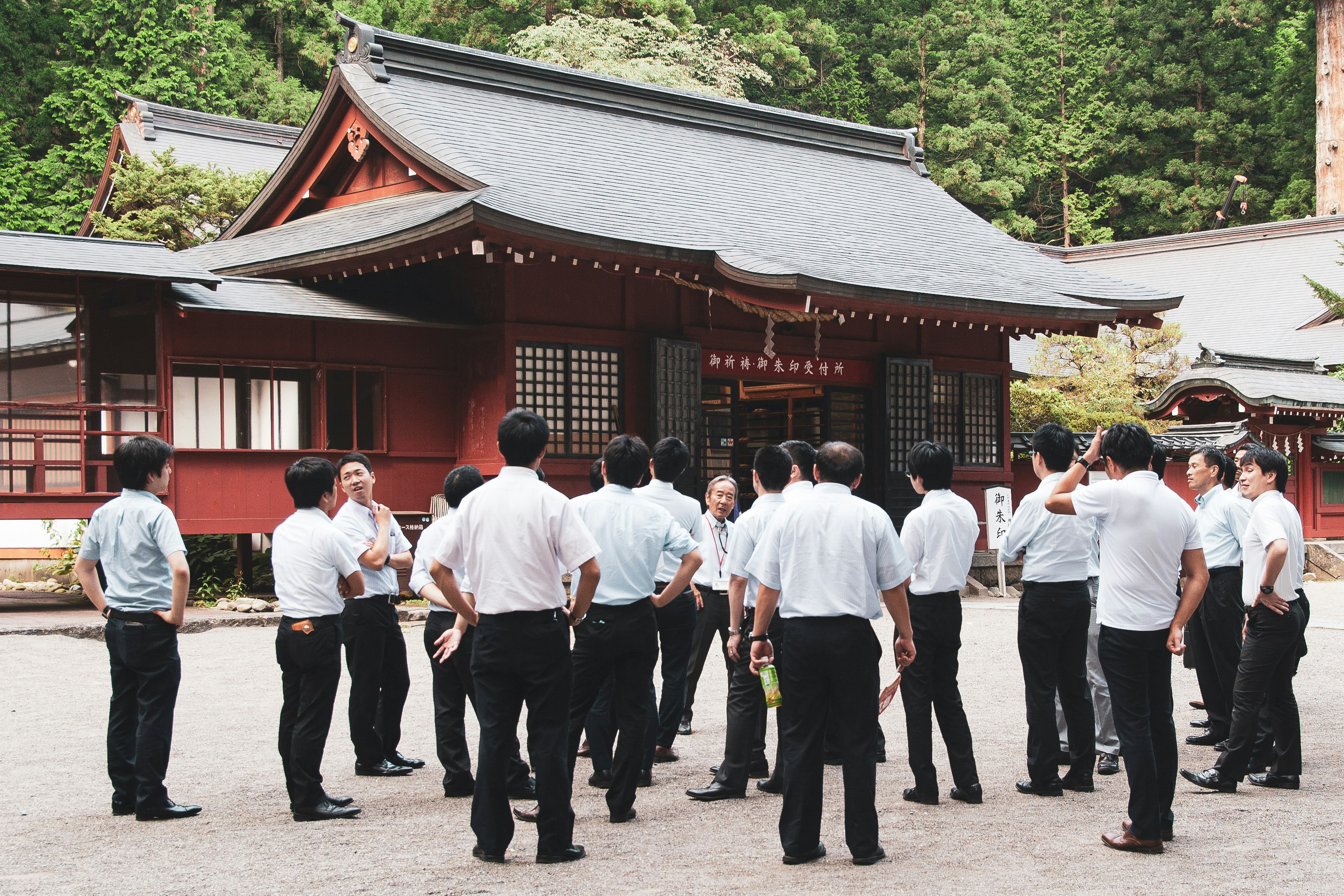 group of people standing near red building during daytime