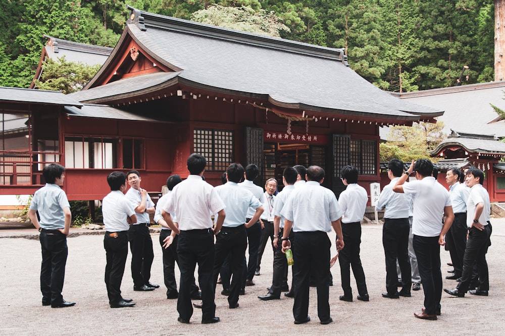 group of people standing near red building during daytime