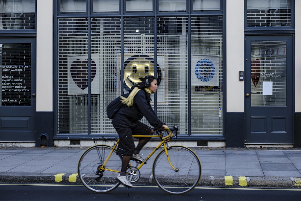 man in black jacket riding yellow bicycle