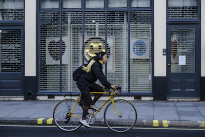 man in black jacket riding yellow bicycle