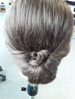 Natural hair styled into a bold updo, framed by rich curls and flawless edges.