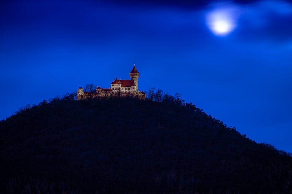 Edificio de hormigón marrón en la cima de la colina durante la noche