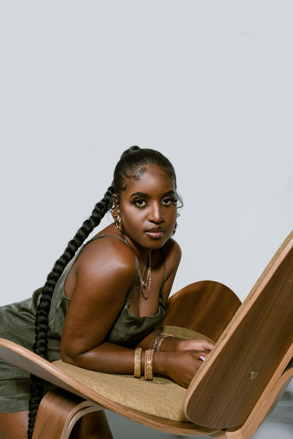 woman in black tank top sitting on brown wooden chair