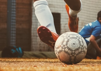 person in white and red soccer jersey kicking soccer ball