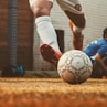 person in white and red soccer jersey kicking soccer ball