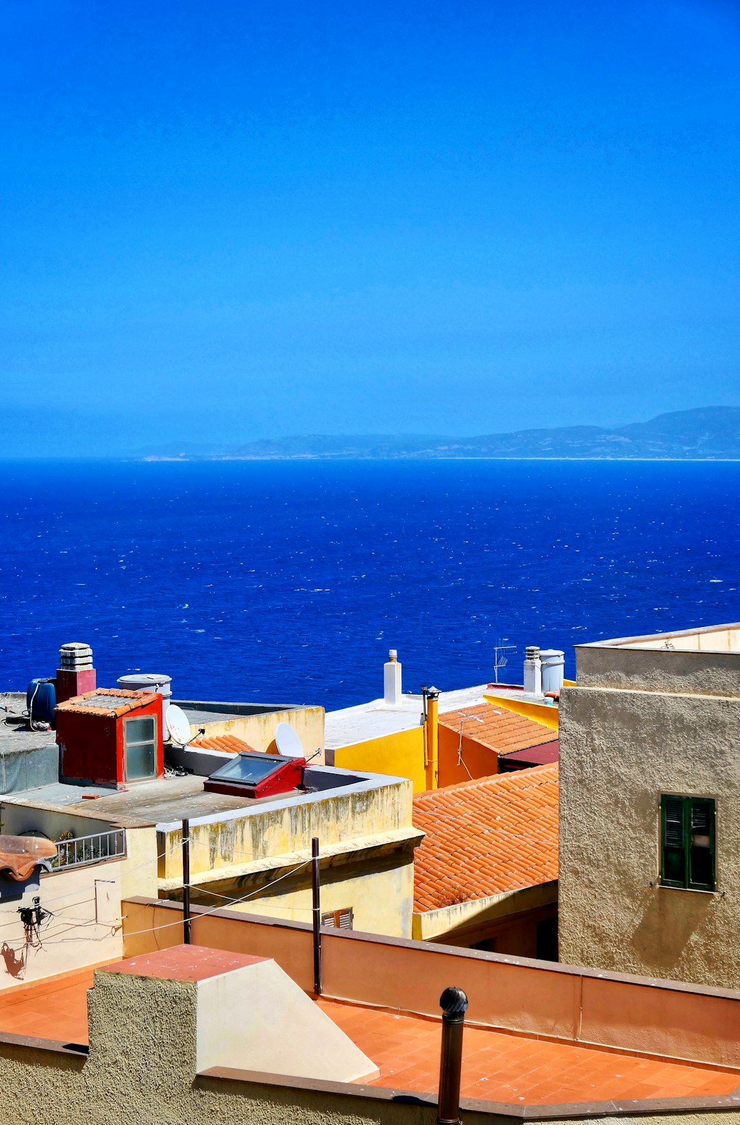 brown concrete houses near sea during daytime